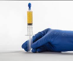 A photo showing a medical professional holding a syringe filled with Pure PRP platelet rich plasma ready for medical use